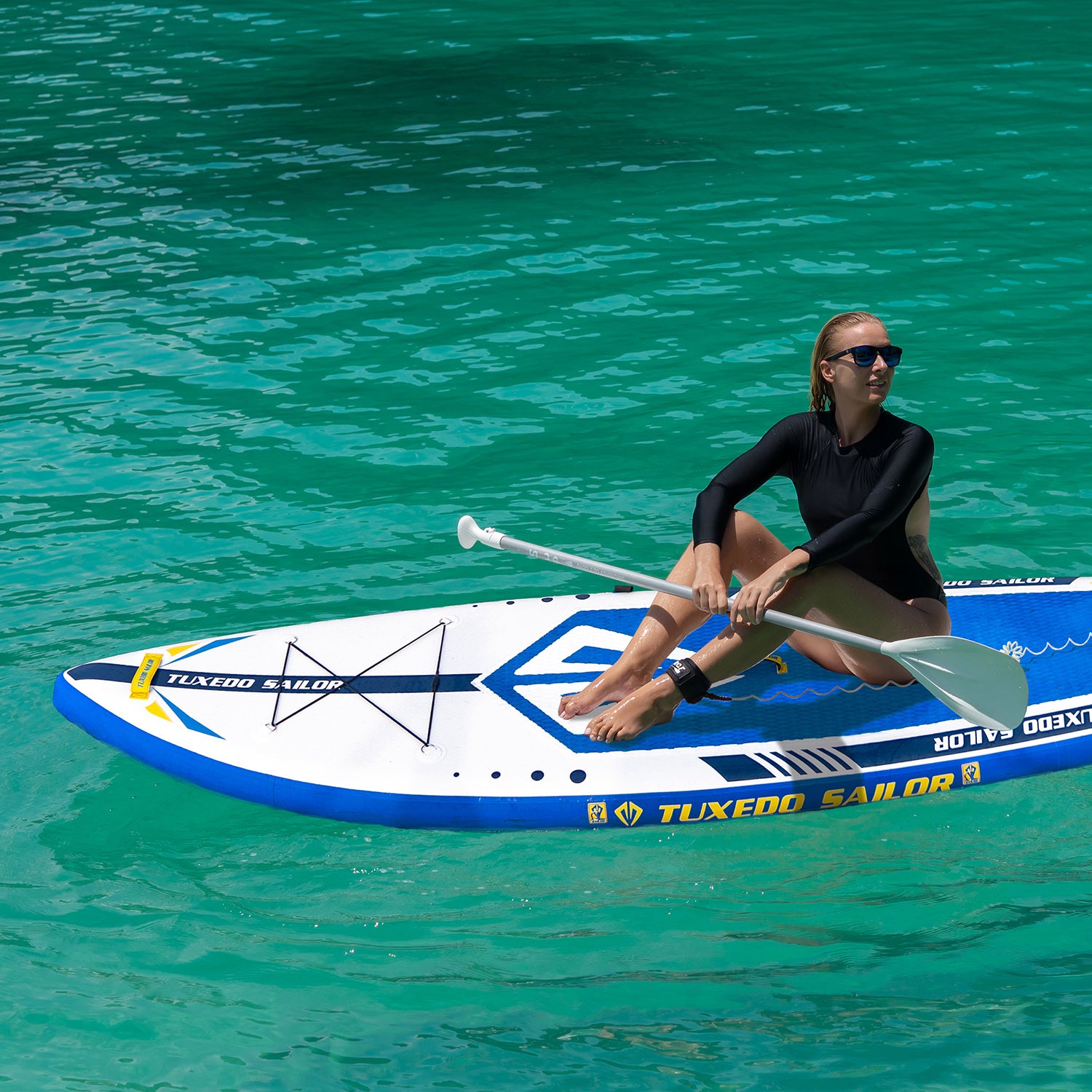 A women was sitting on TUXEDO SAILOR Emblem paddle board