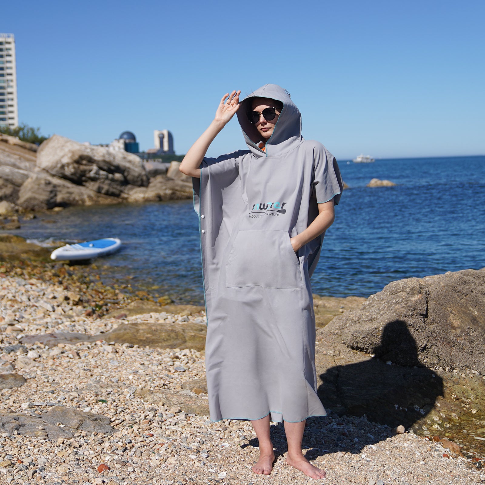 A woman wearing a Funwater gray dress cape at the beach